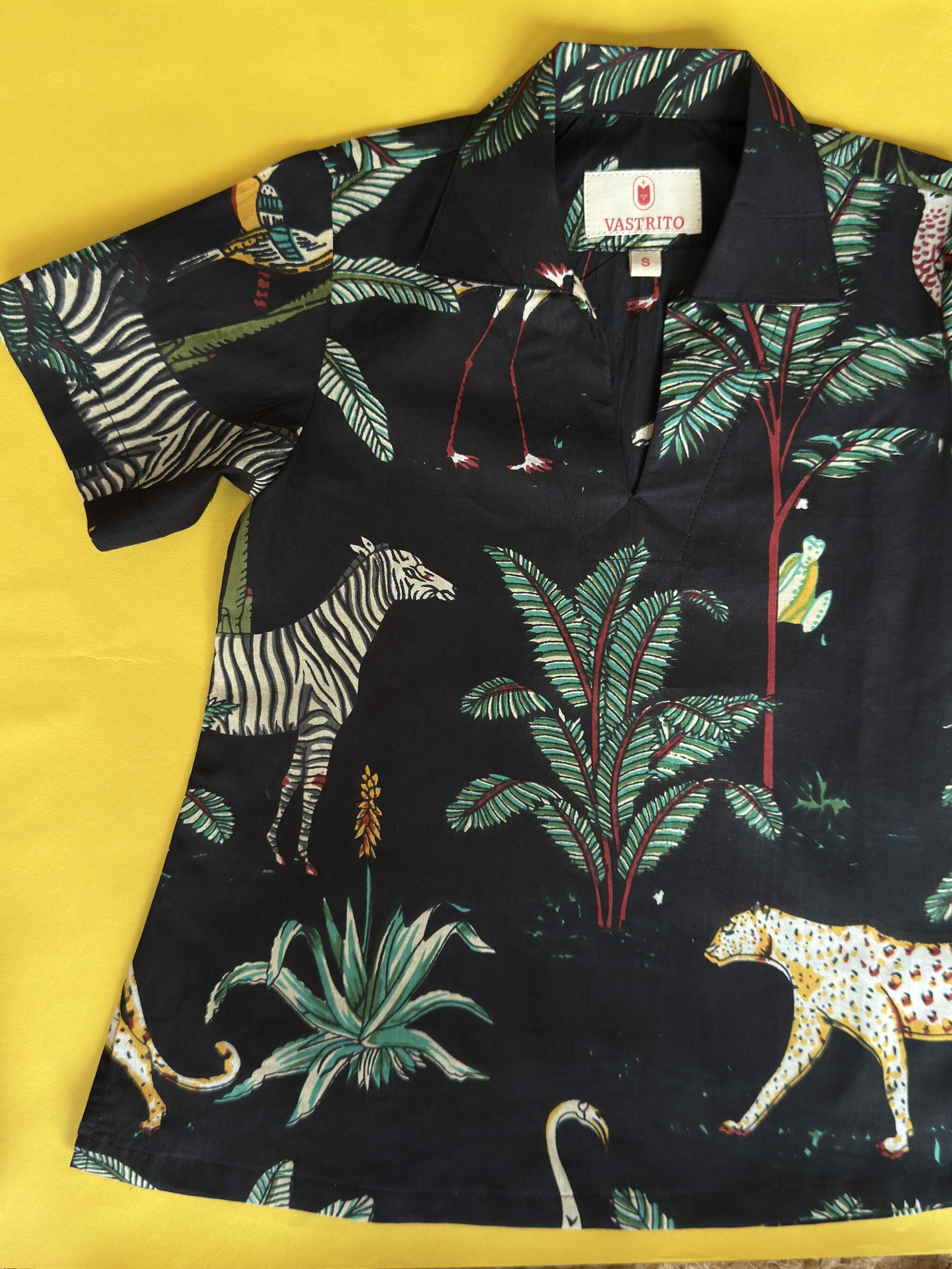 Black shirt with jungle-themed print on a yellow background
