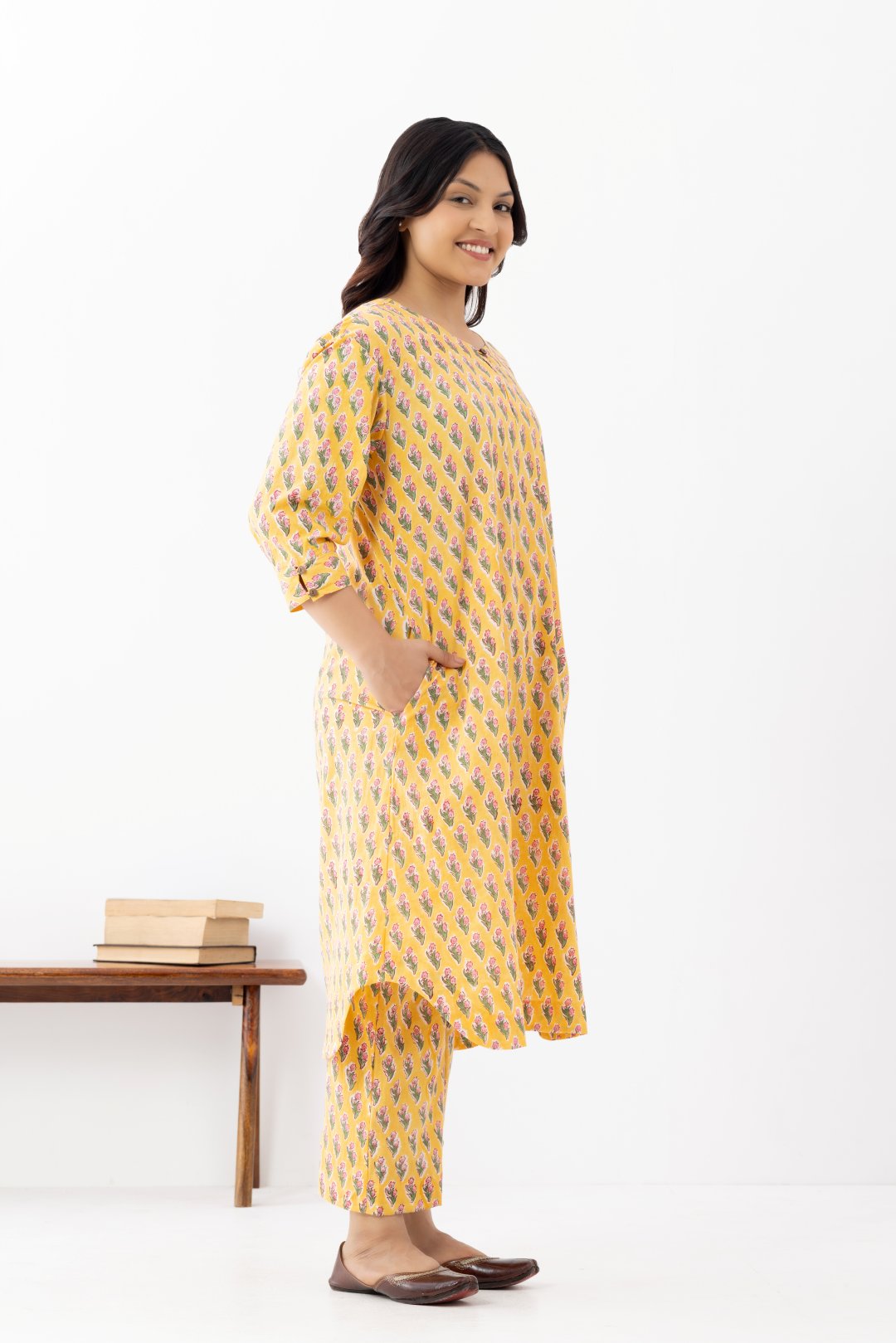 Woman wearing a pure linen booti printed yellow patterned kurta with matching pants and side pockets