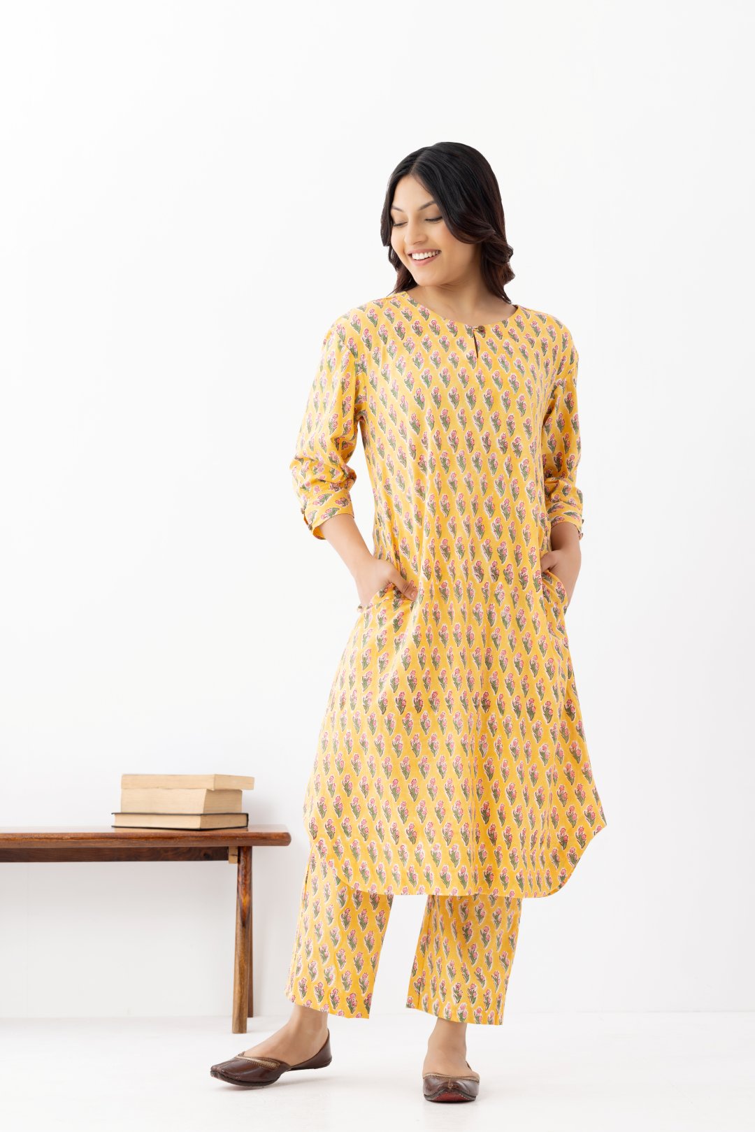 Woman wearing a pure linen booti printed yellow patterned kurta with matching pants and side pockets