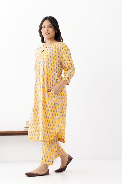 Woman wearing a pure linen booti printed yellow patterned kurta with matching pants and side pockets