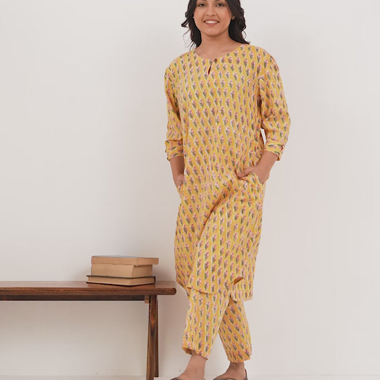 Woman wearing a pure linen booti printed yellow patterned kurta with matching pants and side pockets